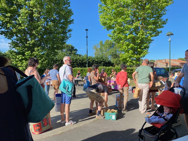 Les habitants au marché Rebi'Goût, sur la place du village de Rebigue